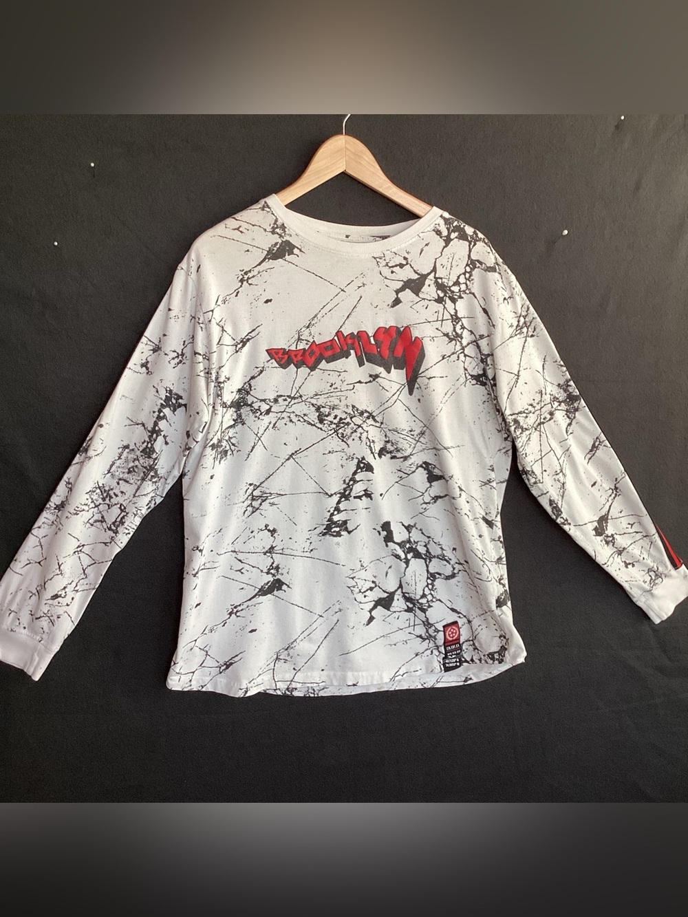 Vox Populi long-sleeve tee marble-like pattern with a red "Brooklyn" graphic